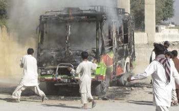 Varios hombres intentan extinguir el fuego en un autobús luego que presuntos militantes islamistas atacaran un vehículo de transporte de pasajeros en Quetta (Foto: EFE)