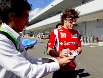 El piloto español Fernando Alonso, de Ferrari, firma autógrafos en el circuito de Suzuka, al oeste de Japón (Foto: EFE)