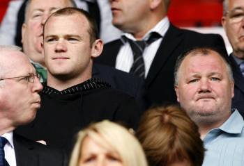 Imagen de archivo tomada el 26 de febrero de 2009 del jugador del Manchester United, Waine Rooney, junto a su padre, Wayne Rooney, durante un partido en Anfield, Liverpool. El padre y el tío del futbolista inglés fueron detenidos hoy por la policía por su