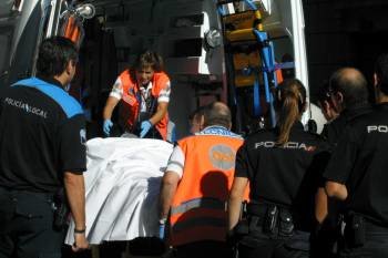 Policías observando como el personal sanitario atiende en la ambulancia a su compañero. (Foto: JOSE PAZ)