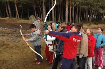 Un grupo de niños practica el tiro con arco en la estación de montaña de Manzaneda. (Foto: MARCOS ATRIO)