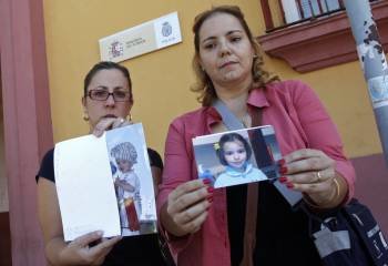 Las tías de los niños, de dos y seis años, desaparecidos en Córdoba con dos fotografías de sus sobrinos. (Foto: RAFA ALCAIDE)
