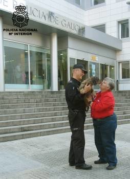 Un policía, con la perra y su dueña.