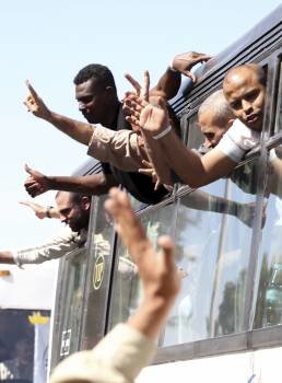 Presos palestinos excarcelados se asoman por la ventanilla del autobús que les llevó hasta el paso fronterizo con Egipto de Rafah (Foto: EFE)