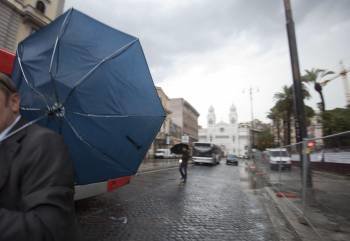 Un hombre intenta avanzar a pesar del fuerte viento y la lluvia, cerca de la Plaza Cavour, durante la tormenta que se registró sobre la capital italiana la mañana de hoy (Foto: EFE)