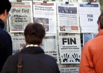 Varias personas leen en un kiosko de San Sebastián las portadas de los periódicos de difusión nacional, así como los diarios de Navarra y el País Vasco (Foto: EFE)