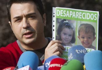 Estanislao Ortiz, tío materno de los niños onubenses Ruth y José, desaparecidos en Córdoba hace tres semanas muestra un cartel con la fotografía de ambos  (Foto: EFE)