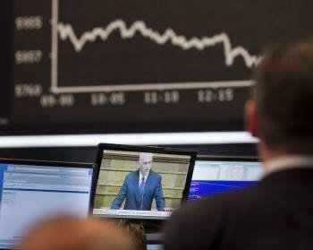 Un experto en bolsa observa al primer ministro griego Papandreou en una pantalla en el parqué de Fráncfort (Foto: EFE)
