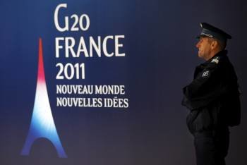  Imagen de un agente de la Policía fancesa, junto al cartel de la Cumbre del G20 que comienza mañana en Cannes, (Foto: EFE)