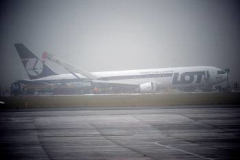  Una grúa (izq) desplazada junto a un Boeing 767, que tuvo que realizar un aterrizaje de emergencia, en el aeropuerto Frederic Chopin de Varsovia (Foto: EFE)