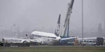 Unos operarios trabajan para retirar del cruce de dos pistas de despegue un Boeing 767 de las líneas aéreas polacas. (Foto: EFE)