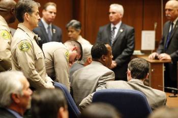Un agente pone las esposas al doctor Murray poco después de que el jurado emitiera su veredicto. (Foto: AL SEIB)