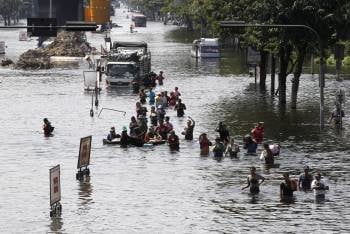Residentes tailandeses atraviesan una calle inundada en el distrito de Bang Khae, Bangkok, Tailandia.