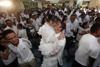 Una pareja de recién casados se besa durante la boda civil masiva celebrada hoy viernes 11 de noviembre de 2011 en Paranaque City, Manila (Foto: EFE)