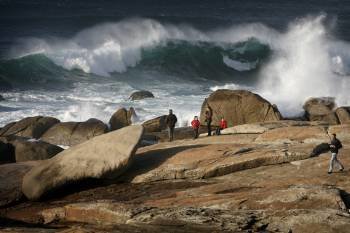 Varias personas observan el oleaje en la costa de la localidad coruñesa de Muxía (Foto: CABALAR)
