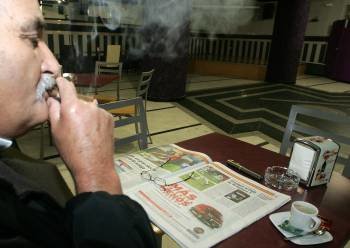Un miembro de la asociación de fumadores celanovesa disfruta de periódico, café y puro. (Foto: MARCOS ATRIO)
