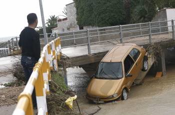 Un vehículo es arrastrado por el agua en un barranco próximo a la localidad castellonense de Vinaroz. (Foto: EFE)