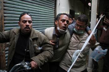 Varios manifestantes egipcios trasladan a un compañero (c) herido a un hospital de campaña tras las protestas contra las fuerzas de seguridad. (Foto: EFE)
