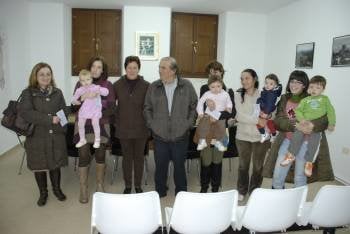 Manuel Corzo, alcalde de O Bolo, con los cuatro niños y sus madres que recibieron ayer su cheque (Foto: LUIS BLANCO)