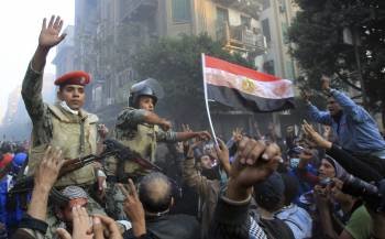 Saldados egipcios aupados a hombros se interponen entre los manifestantes en la Plaza Tahir