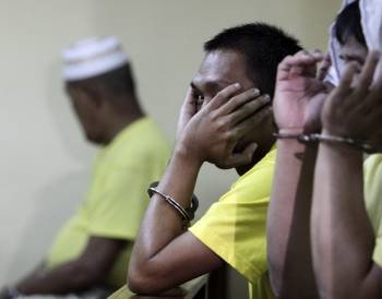 Dos hombres observan durante la audiencia de la matanza en Maguindanao, cuyo segundo aniversario se conmemora hoy, 23 de noviembre de 2011 (Foto: EFE)