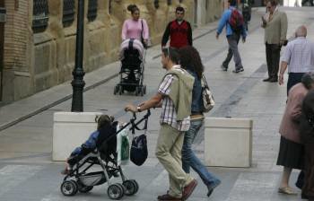 Una pareja joven pasea con su hija por las calles de Huesca.  (Foto: E. J.)