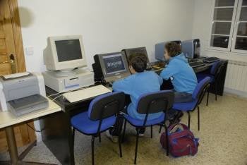 Dos jóvenes usuarios de la red wifi municipal instalada en la biblioteca pública del Teleclub de Petín. (Foto: LUIS BLANCO)