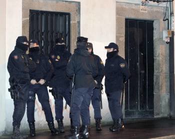 Efectivos de la Policia Nacional permanecen junto a la vivienda de Santiago de Compostela en donde se han realizado varios registros tras la detención ayer de cuatros presuntos miembros del grupo independentista radical Resistencia Galega (RG (Foto: EFE)