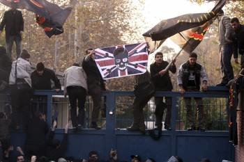 Varios estudiantes islámicos, durante el asalto de la embajada británica en Teherán el martes. (Foto: A. TAHERKENAREH)