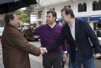Rajoy, en presencia de Núñez Feijóo, saluda a un vecino de Pontevedra. (Foto: SALVADOR SÁS)