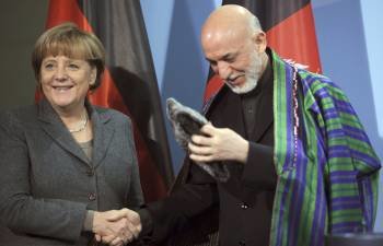 La canciller alemana, Angela Merkel (i) estrecha la mano del presidente afgano, Hamid Karzai (d) tras una rueda de prensa conjunta en Berlín, Alemania (Foto: EFE)
