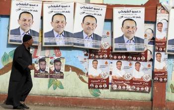 Un hombre pasa delante de unos carteles de propaganda electoral en Giza, Egipto (Foto: EFE)