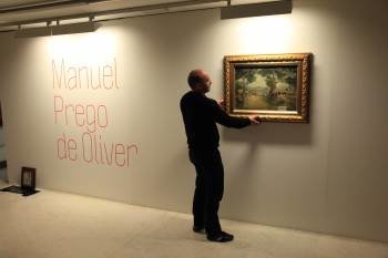 Un operario do Centro Cultural ultima a colocación dos cadros de Prego. (Foto: JOSÉ PAZ)