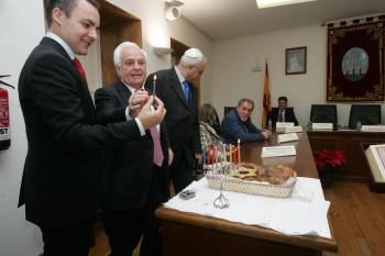 Marcos Blanco entrega la vela a José Luis Baltar para encender el candelabro. (Foto: MARCOS ATRIO)