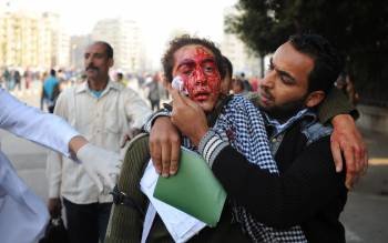 Un hombre ayuda a un manifestante herido en los disturbios. (Foto: MOHAMED OMAR)