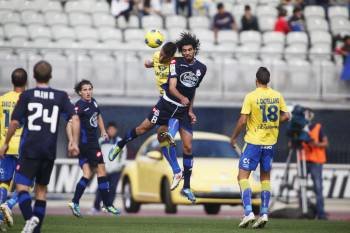 El delantero del Deportivo Lassad busca la misma pelota en el área canaria que un defensor rival. (Foto: J. DIGES)