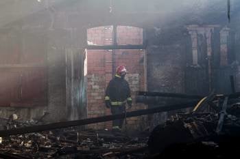 Los bomberos continuaban esta mañana con las labores de control del incendio que la pasada madrugada asoló la fábrica de conservas Paganini de Cangas de Morrazo. (Foto: EFE)