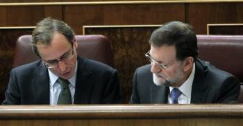 El líder del PP y futuro presidente del Gobierno, Mariano Rajoy (d), charla con el portavoz del grupo popular, Alfonso Alonso, durante la segunda jornada de la sesión de investidura (Foto: EFE)