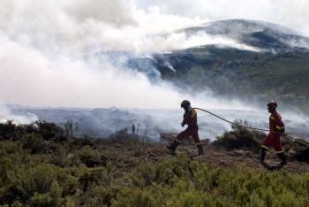 Dos miembros de la UME, participando en la extinción de un incendio en Parada de Sil, en octubre. (Foto: BRAIS LORENZO)