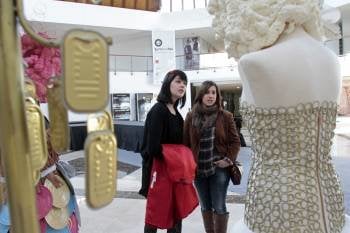 Dos jóvenes observan los detalles de algunas de las piezas que se exhiben en una curiosa exposición de trajes confeccionados con material de reciclaje, inaugurada en el centro Texvigo (Foto: EFE)