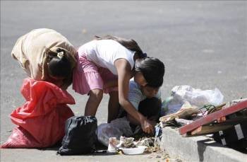 Tres niños recogen alimentos en la calle. (Foto: ARCHIVO)