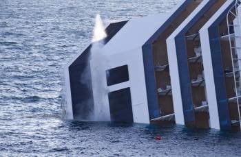 Una columna de humo sale del casco del crucero 'Costa Concordia', semihundido en la costa de la isla de Giglio, como consecuencia de los explosivos utilizados por los servicios de rescate para volar los escombros  (Foto: EFE)
