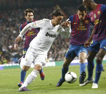 Özil intenta escapar de Messi, Busquets y Abidal, el miércoles en el clásico contra el Barcelona. (Foto: KIKO HUESCA)
