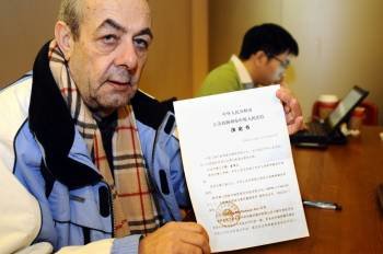 Cándido Rodríguez Eiró, en China, muestra la denuncia. (Foto: ZIGOR ALDAMA (EL PAÍS))