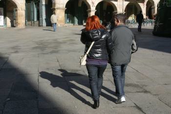 Una pareja camina cogida del brazo por el centro de la Praza Maior, en la ciudad.  (Foto: José Paz)