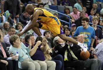 El jugador de los Hornet de Nueva Orleans Jarret Jack salta al público buscando una bola ante los Mavericks de Dallas (Foto: EFE)