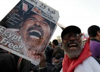 Un hombre muestra un cartel alusivo a la revolución egipcia en la concentración en la plaza Tahrir