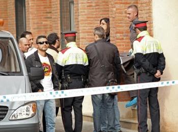Operarios de los servicios funerarios transportan, ante varios mossos d'esquadra, el cadáver de una mujer de unos 50 años que ha sido hallado esta mañana en un piso de Granollers  (Foto: EFE)
