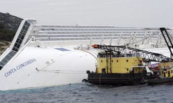 Un buque faena junto al casco semihundido del crucero 'Costa Concordia'. (Foto: CARLO FERRARO)