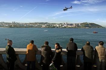 Varias personas observan el operativo de búsqueda de los tres desaparecidos en A Coruña (Foto: CABALAR)